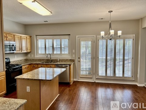 A kitchen with wooden cabinets and a granite countertop.