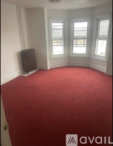 A room with red carpet and a window.
