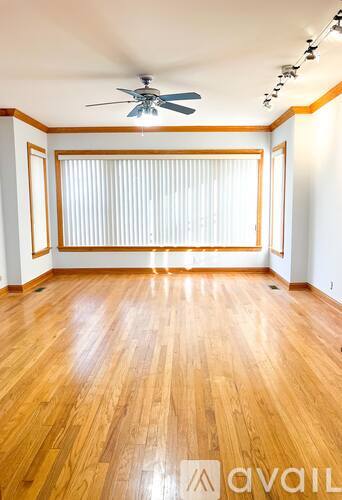 A room with wooden floors and a ceiling fan.