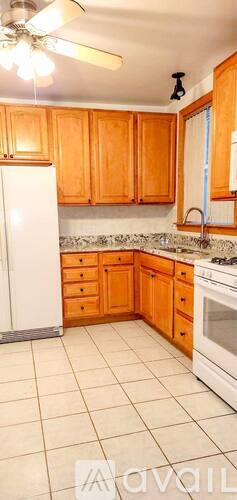 A kitchen with wooden cabinets and white appliances.