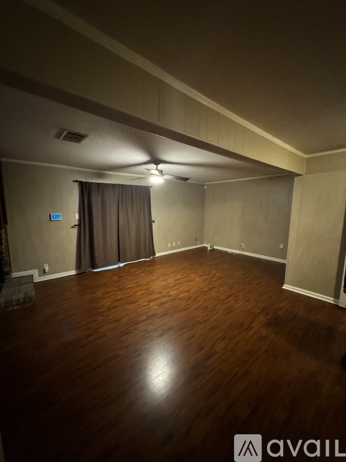 A room with wooden flooring and a ceiling fan.