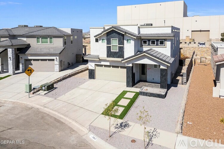 A modern house with a grey roof and a white garage door.