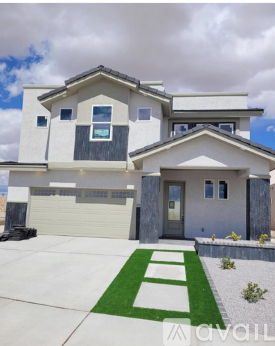 A modern house with a white garage door and a green lawn in front.