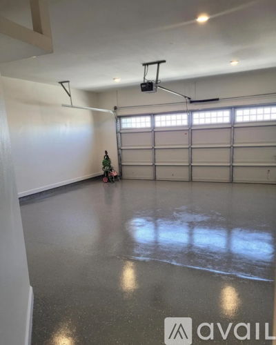 A spacious garage with a grey floor and white walls.