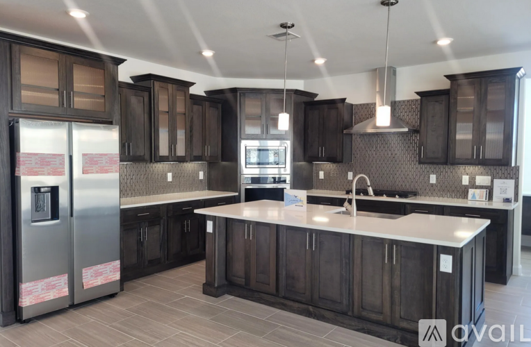 A kitchen with dark wood cabinets and a central island.