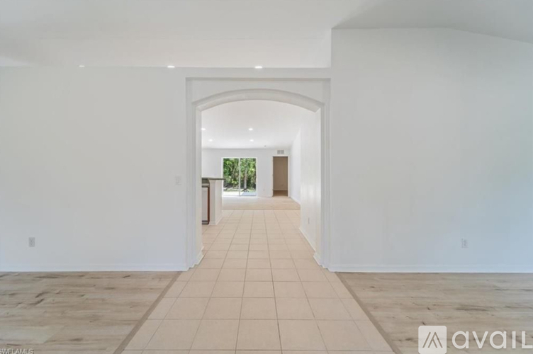 A spacious room with white walls and a tiled floor.