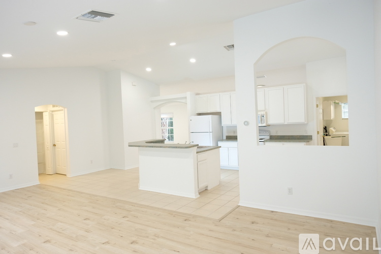 A spacious kitchen with white cabinets and a large island.