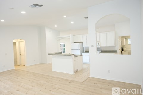 A spacious kitchen with white cabinets and a large island.