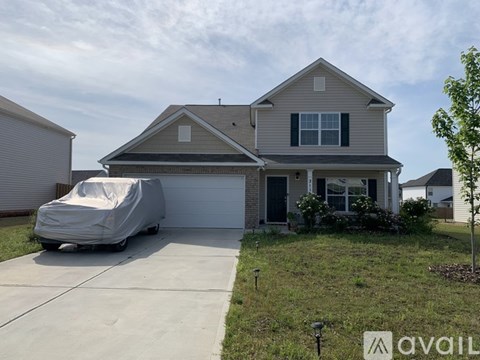 A house with a covered carport and a white car in front.