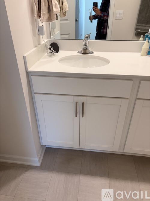 A bathroom with a white sink and cabinets.