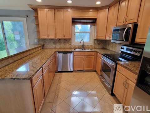 A kitchen with wooden cabinets and granite countertops.