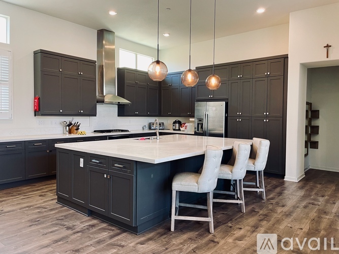 A modern kitchen with dark brown cabinets and a white island.