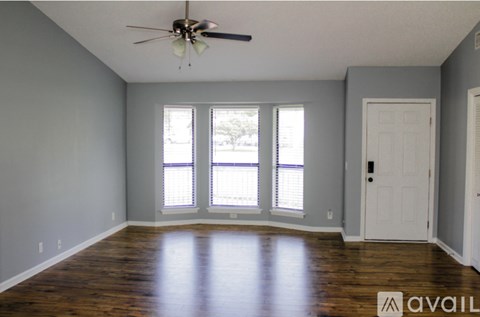 A room with a ceiling fan and wooden floors.