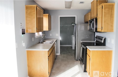 A kitchen with wooden cabinets and a refrigerator.