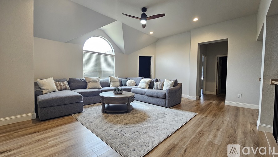A living room with a grey couch and a round coffee table.