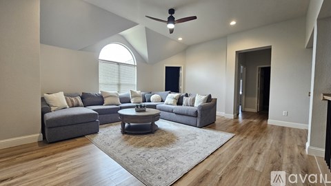 A living room with a grey couch and a round coffee table.
