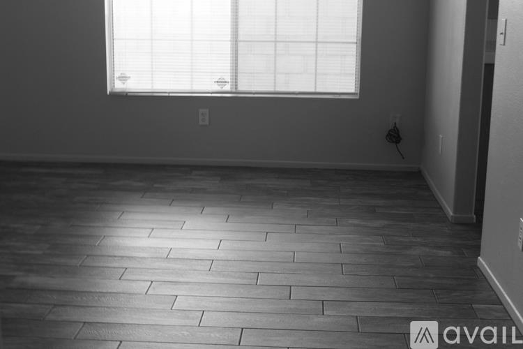 A room with a window and wooden flooring.