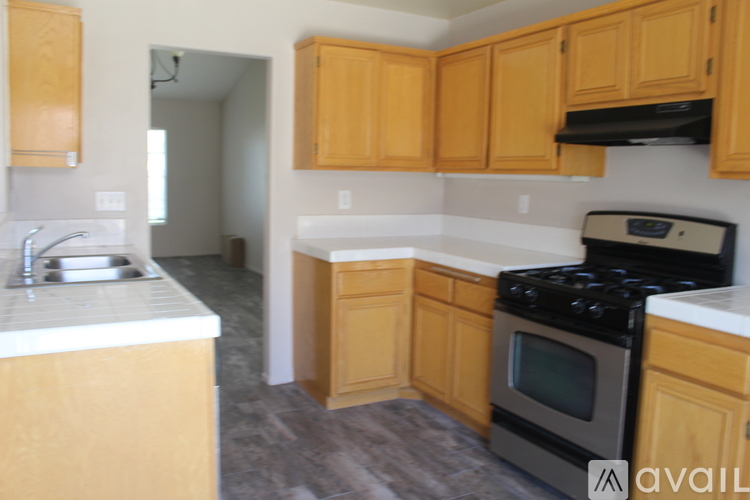 A kitchen with wooden cabinets and a black stove top oven.