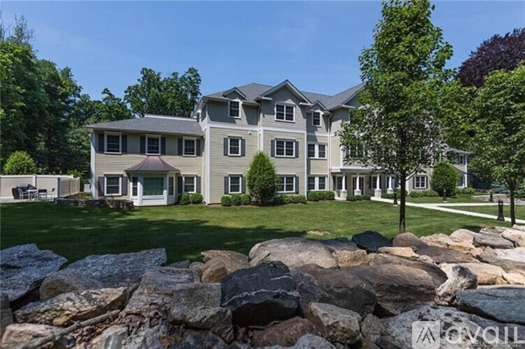 A large house with a stone wall in front.