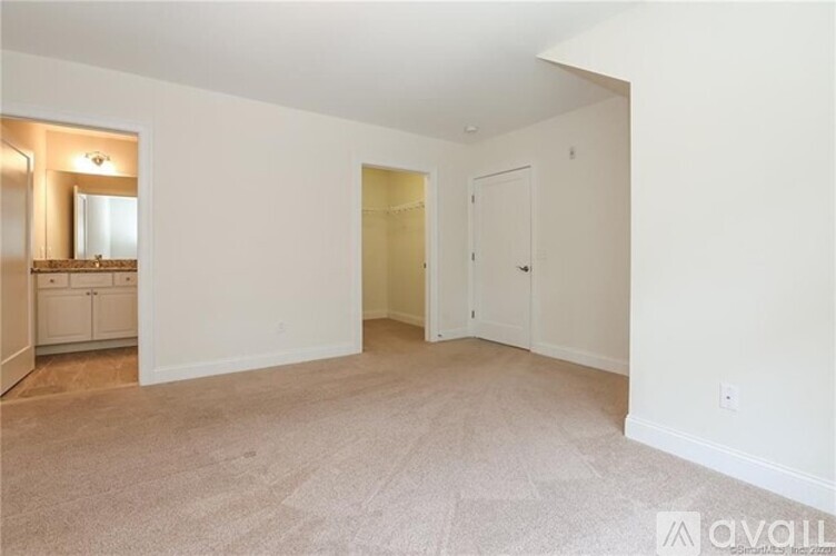 A spacious room with a carpeted floor and white walls.
