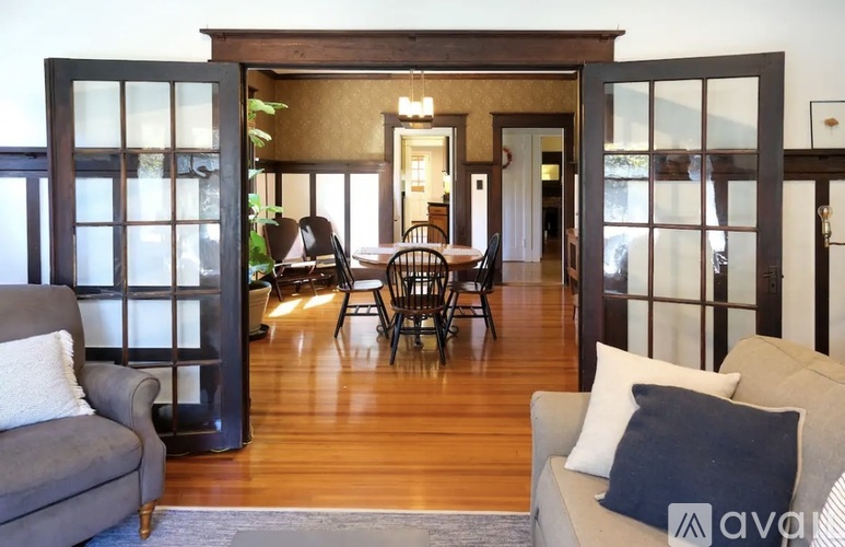 A living room with a grey couch and a wooden floor.