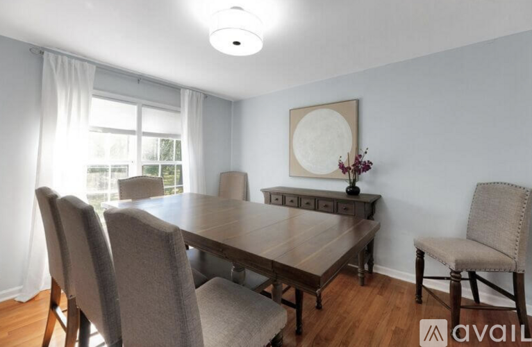 A dining room with a wooden table and chairs.