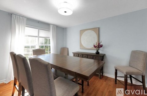 A dining room with a wooden table and chairs.