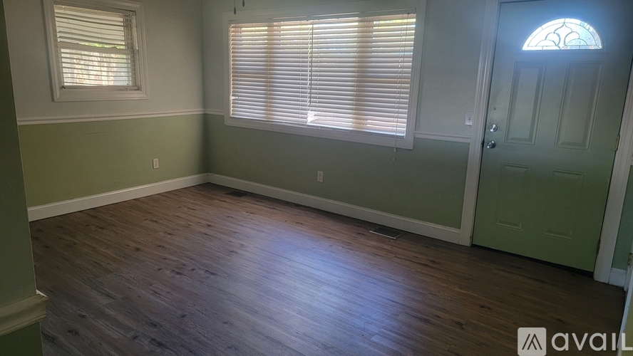 A room with wooden floors and a green door.