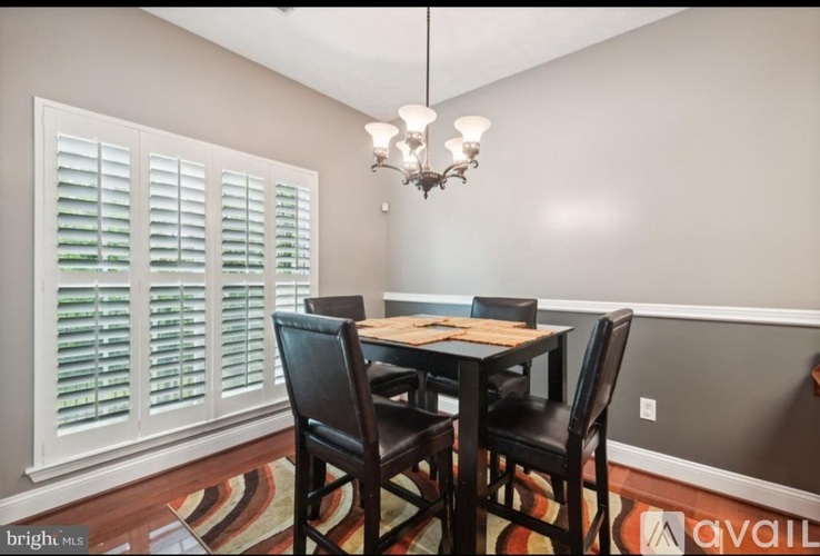 A dining room with a table and chairs.