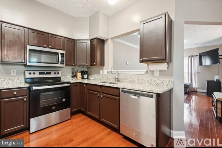 A kitchen with brown cabinets and stainless steel appliances.