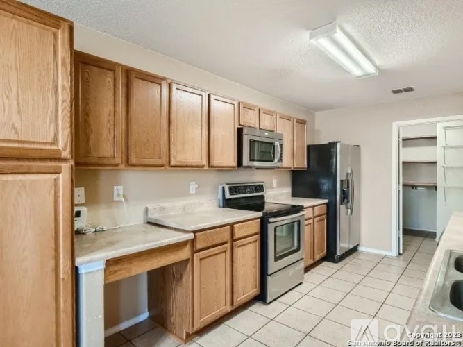 A kitchen with wooden cabinets and black appliances.