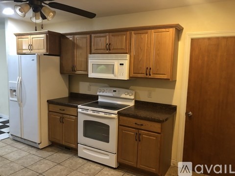A kitchen with wooden cabinets and a white refrigerator.