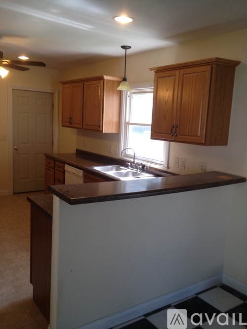A kitchen with wooden cabinets and a checkered floor.