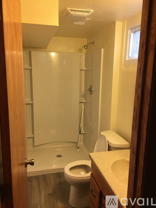A bathroom with a toilet, sink, and shower.