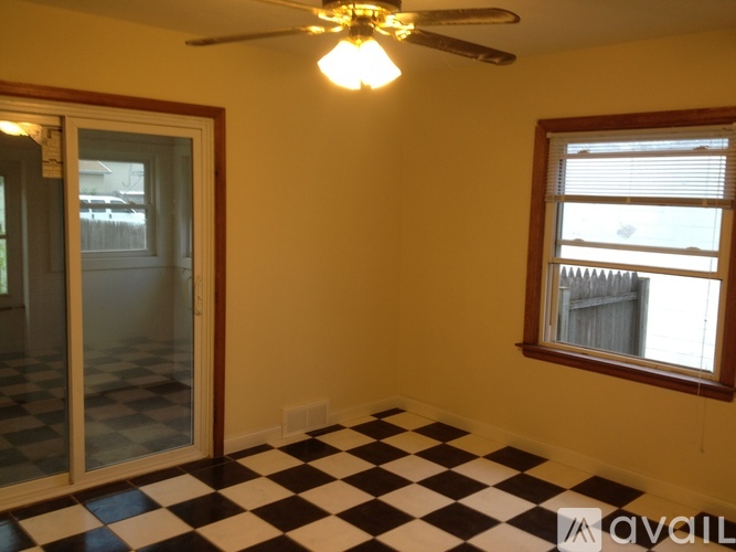 A room with a checkered floor and a ceiling fan.