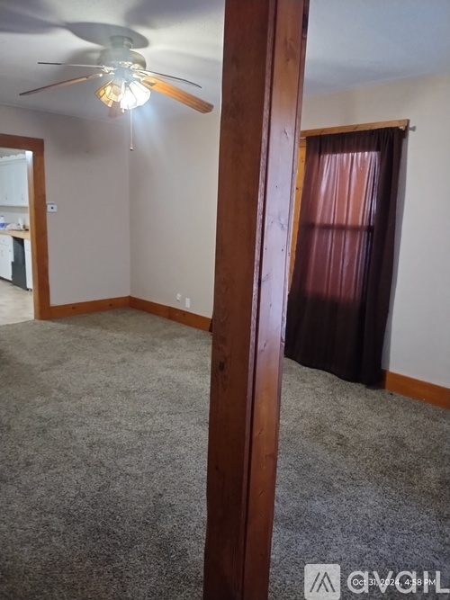 A room with a ceiling fan and a carpeted floor.