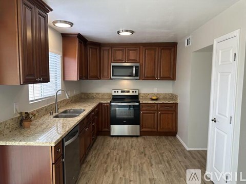 A kitchen with wooden cabinets and a granite countertop.