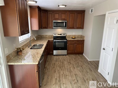 A kitchen with wooden cabinets and a stove top oven.