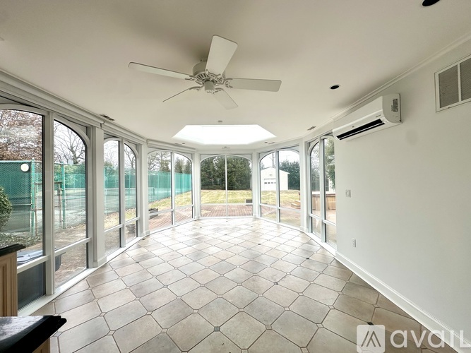 A spacious room with a ceiling fan and tiled flooring.