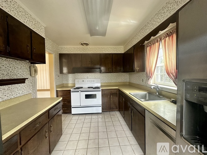 A kitchen with a white stove top oven and a white dishwasher.