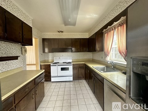 A kitchen with a white stove top oven and a white dishwasher.