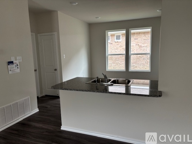 A kitchen with a granite countertop and a window.