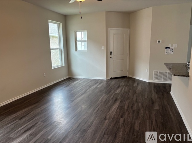 A room with wooden flooring and a ceiling fan.