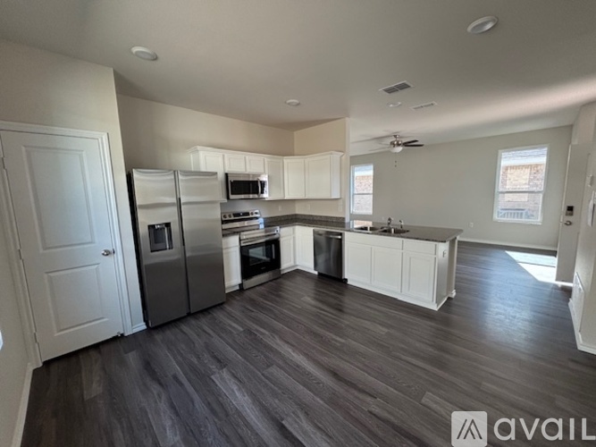 A spacious kitchen with white cabinets and stainless steel appliances.