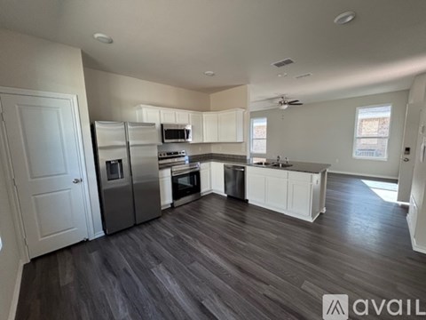 A spacious kitchen with white cabinets and stainless steel appliances.