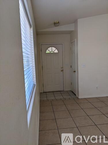 A hallway with a door and tiled floor.