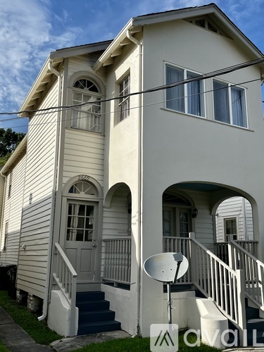 A white two-story house with a satellite dish on the roof.