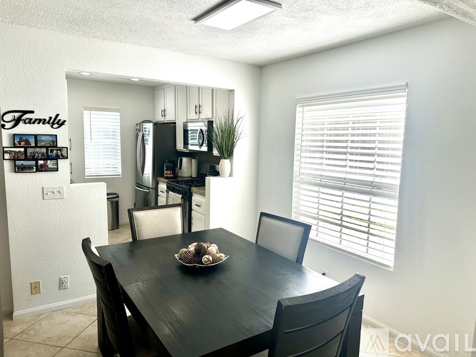 A dining room with a black table and chairs.