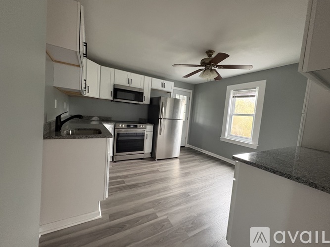 A kitchen with a refrigerator, oven, and microwave.