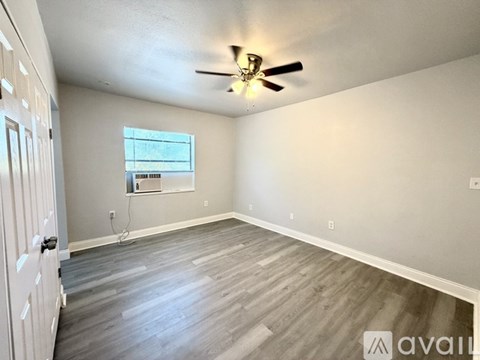 A room with a ceiling fan and a window.